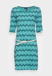 Turkusowa sukienka w wzory z rękawami o długości trzech czwartych, z nadrukiem w formie zygzakowatych drzew, białym paskiem i dekoracyjnymi guzikami.