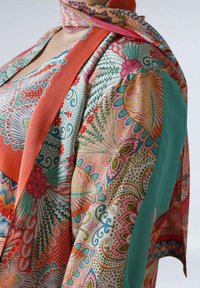 Tissu coloré et à motifs avec des motifs floraux et de feuilles complexes dans des nuances de corail, turquoise et pastels. Texture douce et design fluide.