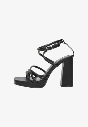 Sandalias negras de tacón alto con un tacón cuadrado grueso, con múltiples correas en cruz y un hebilla en el tobillo para un ajuste seguro. Textura suave.