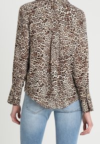 Langærmet bluse med leopardmønster og knapkrave, lys beige og brune nuancer, blødt stof, buet kant og to læg bagpå.