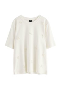 Hvid kortærmet T-shirt med rund hals, prydet med teksturerede sløjfer jævnt fordelt over stoffet. Glat, blødt materiale.