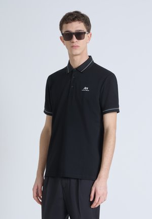 Zwart polo shirt met een contrasterende grijze kraag, knoopsluiting met drie knopen, klein logo op de borst, en korte mouwen met grijze accenten.