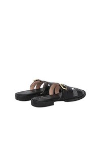 Zwarte leren sandalen met een open ontwerp, voorzien van meerdere banden en een goudkleurige gesp als accent. De zool is vlak met een lichte textuur.