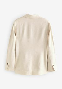 Beige blazer lavet af textureret stof. Har en spidset krave, lange ærmer med knapdetaljer og en central rygslids.