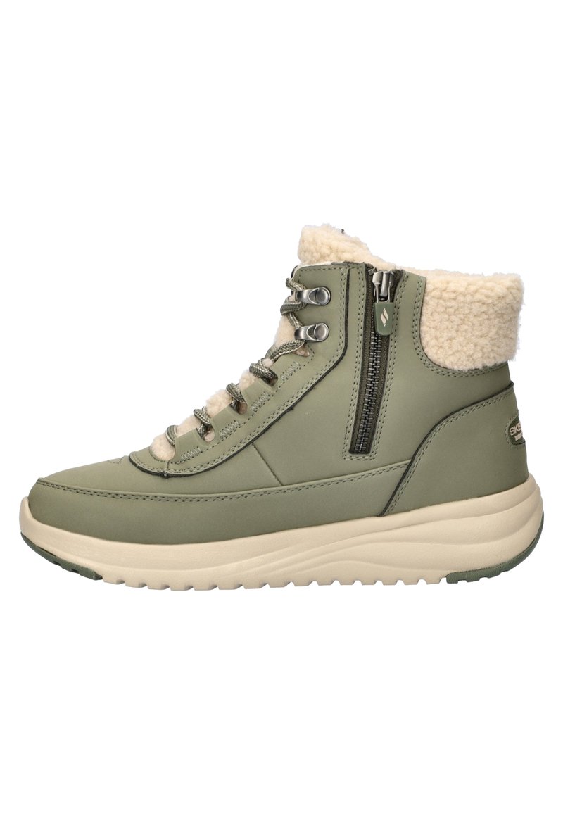 Groene waterdichte laars met een fleece-gevoerde kraag, metalen oogjes, zijrits en een lichtgewicht beige zool met een gestructureerde grip.