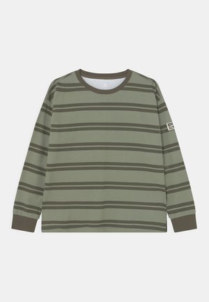 Langärmeliges olivgrünes Hemd mit dunklen horizontalen Streifen, dunklem Kragen und Manschetten sowie einem kleinen Aufnäher am linken Ärmel.