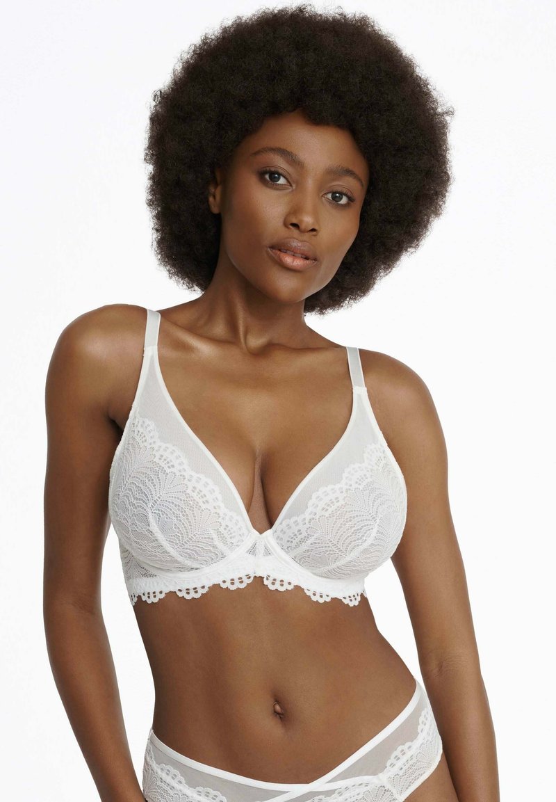 White lace bra with a plunging neckline, featuring scalloped edges and thin adjustable straps, complemented by a matching lace band.