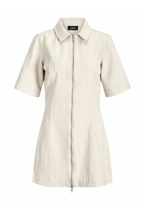 Krótka kremowa kurtka z krótkimi rękawami, kołnierzem, pionowymi przeszyciami i zamkiem błyskawicznym z przodu.