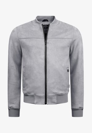 Harmaa pomppujakku pehmeässä, tekstuurilla varustetussa kankaassa. Varustettu edessä olevalla vetoketjulla, ribbaamilla hihoilla ja hillityllä kiillolla, sekä huomaamattomalla logolla sivussa.