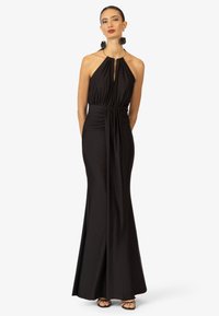 Schwarzes Neckholder-Kleid mit einem Schlüssellochausschnitt, gerafftem Taillenbereich und einer figurnahen Silhouette. Glatter Stoff mit einem fließenden Rock.