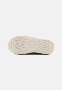 Σόλα παπουτσιού με υφή ζιγκ-ζαγκ σε ανοιχτό μπεζ καουτσούκ, σχεδιασμένη για αντοχή και πρόσφυση.