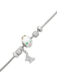 Il braccialetto in argento presenta un charm a forma di maialino in ceramica bianca con dettagli verdi e rosa, intervallato da pietre argentee e scintillanti, e un charm a forma di farfalla.