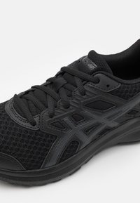 Černá sportovní bota s horní částí z prodyšné síťoviny a syntetickými akcenty. Vybavena texturovanými černými tkaničkami a logem, se zvlášť pohodlnou podrážkou pro oporu.