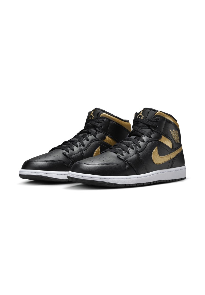 Zwarte leren high-top sneakers met gouden accenten, voorzien van een geperforeerde teendoos, een gewatteerde kraag en een witte rubberen zool.