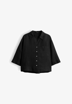 Zwart langharig overhemd met knopen, brede mouwen, een kraag en een borstzak, plat gelegd op een witte achtergrond.