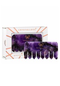 Lila Edelsteinkamm mit spitzen Zähnen, zeigt natürliche Marmorierung. Verpackt in einer weißen Box mit roségoldenen Akzenten und Markenlogo.