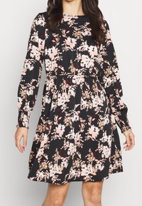 Floral dress with long sleeves, black base, and pink, beige, and burgundy flower patterns. Cinched waist and gathered skirt detail.