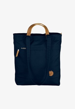 Marineblaue Tragetasche mit braunen Ledergriffen, Vordertasche mit Reißverschluss und kleinem Fuchs-Logo am unteren Eck.
