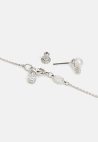 Sterling zilveren sieradenset bevat een ketting met een heldere cubic zirconia bedel en een pareloorbel met metalen achterzijde.