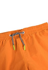 Oranga badshorts med elastisk midja, utrustade med ett svart och vitt dragsnöre med gröna spetsar och ett mjukt, lätt tyg.