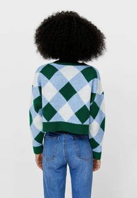 Cropped sweater featuring a diamond pattern in green, light blue, and white, with a ribbed green hem and long sleeves. Cotton blend material.