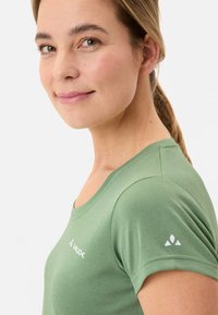 Groene, korte mouwen shirt gemaakt van zacht, textuur materiaal. Heeft een ronde halslijn en een klein logo aan de linkerkant en op de mouw.