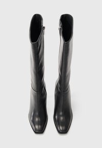Black leather knee-high boots with a square toe design. Features a sleek silhouette and side zippers for easy wear. Smooth texture.