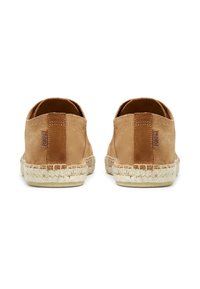 Béžové semišové slip-on boty s přírodní jutu podešví; mají šitý detail na patě a hladký povrch na svršku.