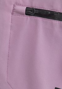 Lila tyg med en slät yta, som har en ficka med dragkedja och kontrasterande svarta dragkedjedetaljer. Enkel design, inga mönster.