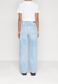 Ljust blå, högmidjade vida jeans med två bakfickor och en logotypetikett. Lös passform, denimtyg med en något urtvättad struktur.