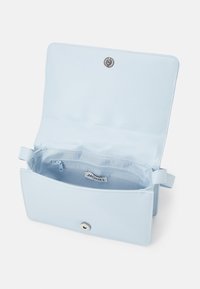 Borsa in pelle azzurro chiaro con una texture liscia, chiusura a scatto magnetico e una tasca interna. Presenta un'etichetta con la scritta "MONKL".