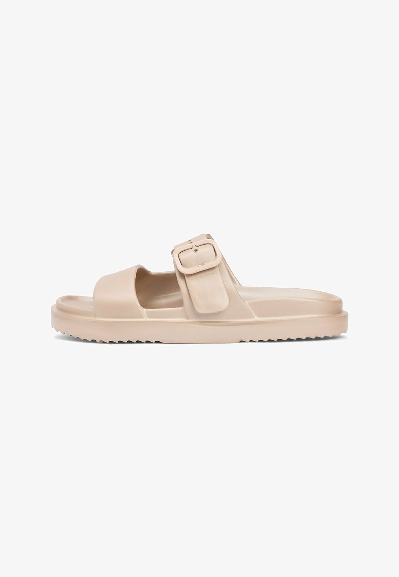 Sandalia tipo 'slide' beige con puntera abierta, suela gruesa y una gran correa ajustable con hebilla sobre el pie.