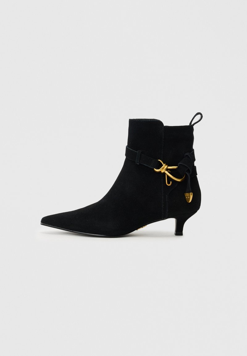 Black suede ankle boot with a pointed toe, decorative strap and gold hardware accent, featuring a low kitten heel and pull tab at the back.