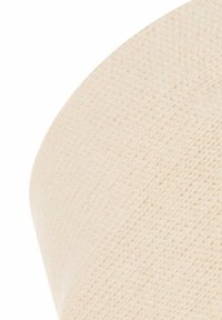 Tissu tricoté beige, texture douce, avec un motif côtelé et un léger éclat, présentant un bord courbé et roulé.