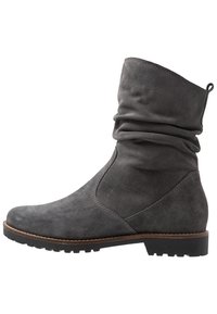 Bottine en daim gris avec une tige relâchée, un bout rond et une semelle en caoutchouc texturé. Présente un détail de couture contrastant en marron.