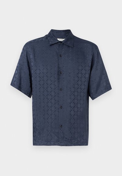 Kortermet marineblå skjorte med knapper, subtilt rutemønster og klassisk krage, vist på ensfarget lyst bakgrunn.