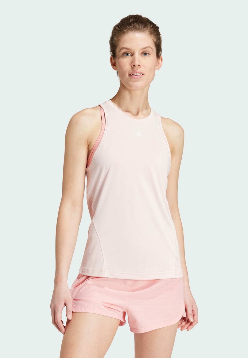 Light pink athletic tank top with a fitted design and sleeveless style, paired with matching light pink shorts, made from breathable fabric.