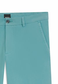 Jasnoniebieskie, dopasowane szorty z płaskim przodem, pojedynczym zapięciem na guzik i dwiema bocznymi kieszeniami. Wykonane z gładkiego materiału o czystym wykończeniu.