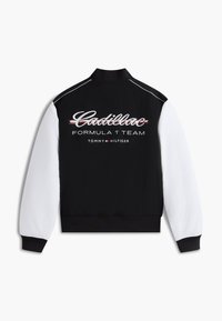 Μαύρο και άσπρο τζάκετ στυλ varsity με λογότυπα "Cadillac Formula 1 Team" και "Tommy Hilfiger" στην πλάτη, ριμπ γιακά και μανσέτες.