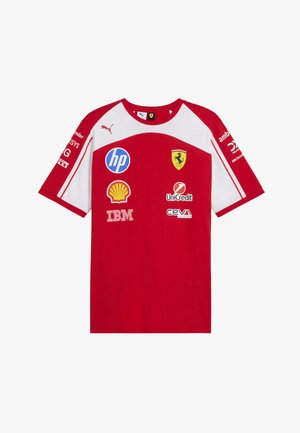 Camiseta de carreras Ferrari en rojo y blanco con el logo de Puma y logotipos de patrocinadores que incluyen HP, Shell, IBM, UniCredit y CEVA en el frente y las mangas.