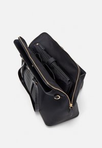 Svart strukturerad läderhandväska med dragkedjestängning, som har guldfärgad hårdvara, flera fack och en slät innerfoder.