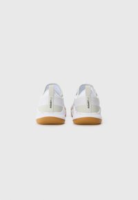Hvide sneakers med en tekstureret overdel, elastisk bagstrop og en beige accent. Sålen er gummi med en gummifarvet underside.