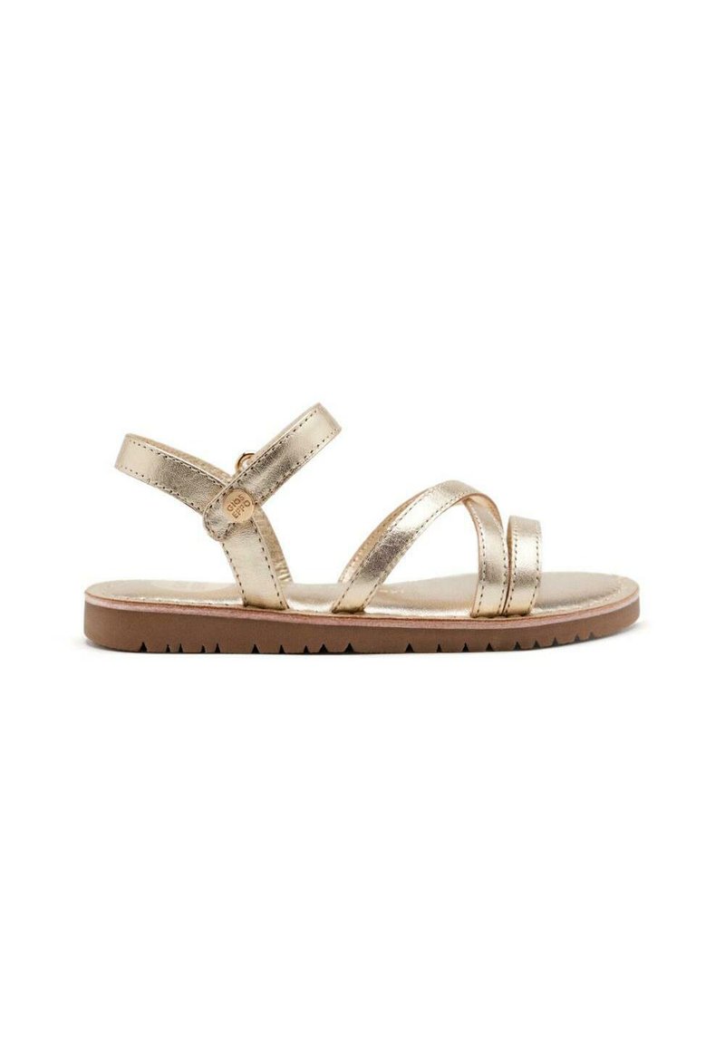 Sandalias metálicas doradas con suela plana de goma, que presentan tres correas estrechas y una correa de tobillo ajustable. Textura suave y diseño minimalista.