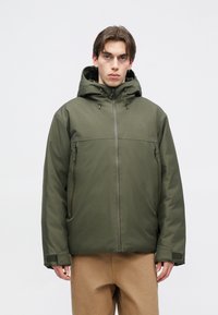 Maslinasto zelena izolirana jakna s kapuljačom, džepovima na zip, i podesivim manžetama. Ima glatku teksturu i minimalistički dizajn bez uzoraka.