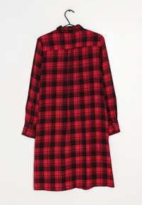 Červené a černé kostkované šaty s dlouhými rukávy, límečkem a manžetami na knoflíky. Vyrobené z tkaniny s měkkou texturou.
