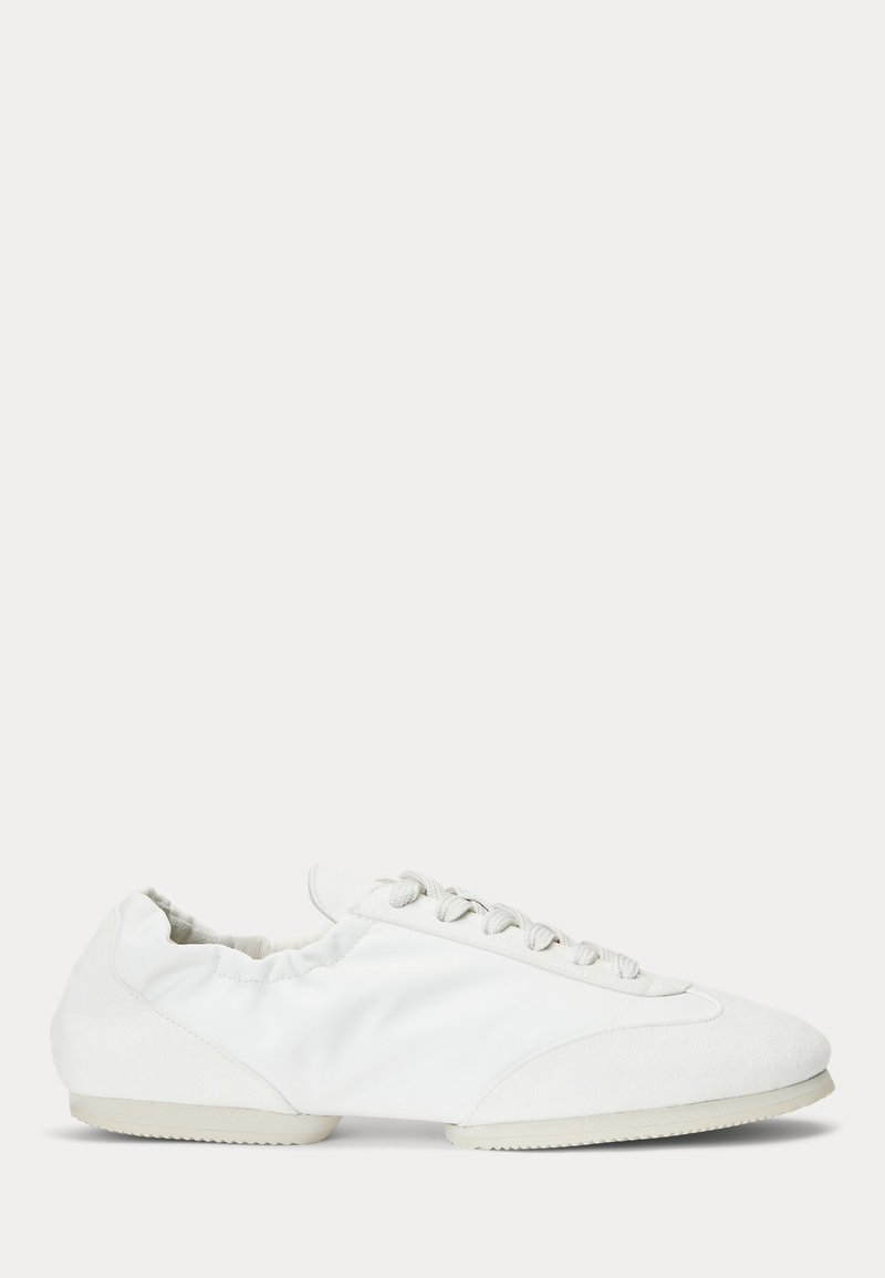 Bijela cipela s gornjim dijelom od mekog tekstila, detaljima od antilopa i elegantnim dizajnom. Ima vezanje na pertle sprijeda i lagani gumeni potplat.