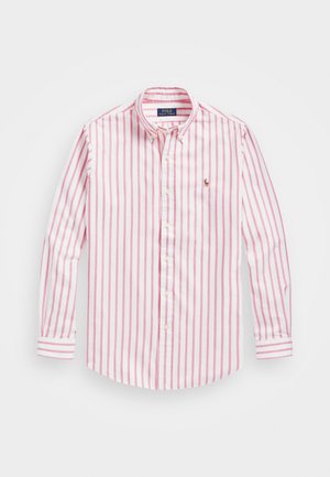 Chemise à manches longues, boutonnée, avec des rayures verticales roses et blanches et un petit logo brodé sur le côté gauche de la poitrine.