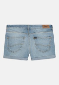 Pantalones cortos de denim en azul claro con dobladillo enrollado. Cuenta con dos bolsillos traseros con detalles de costura y una etiqueta de cuero marrón en la cintura.