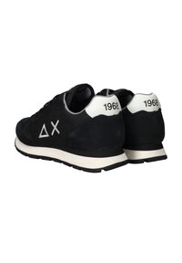 Schwarze Sneakers mit weißer Sohle, weißer Fersenschlaufe, die mit "1968" gekennzeichnet ist, sowie weißen griechischen Delta- und Buchstaben-X-Logos an der Seite.