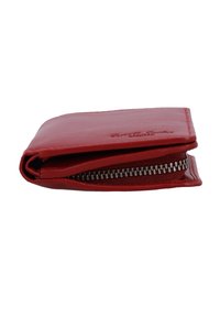Gefaltete rote Lederbrieftasche mit sichtbarem silbernem Reißverschluss an der Seite vor weißem Hintergrund.